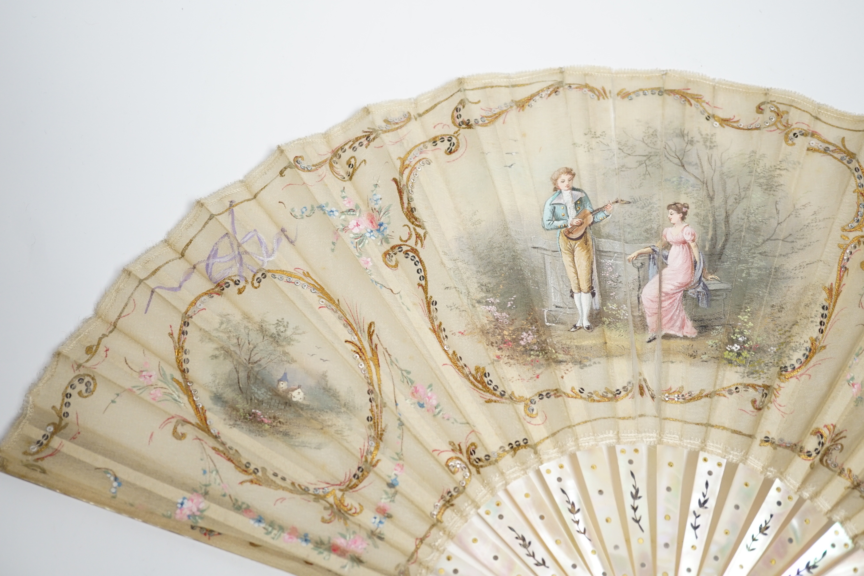 An Edwardian mother of pearl and fine gauze hand painted fan in satin and sequin case